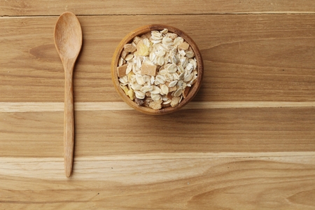 Oat flakes in wooden scoop on wooden background ,Vintage style