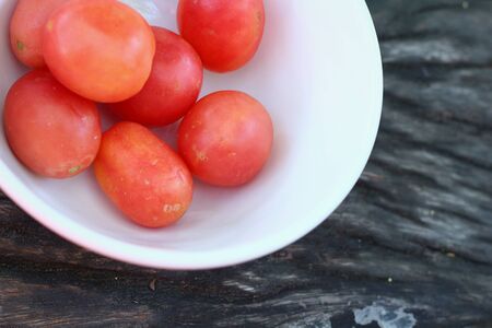 Fresh tomatoes on rustic wooden backgroundの写真素材