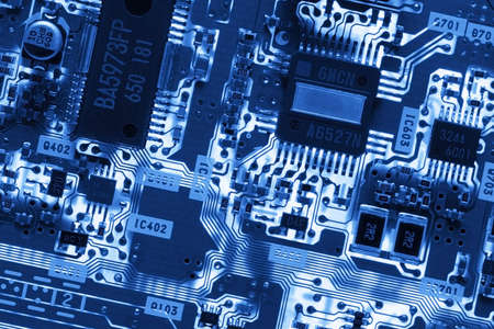 Blue Glowing Circuit Board. Close-up detail of a computer circuit board. The blue toned high tech...