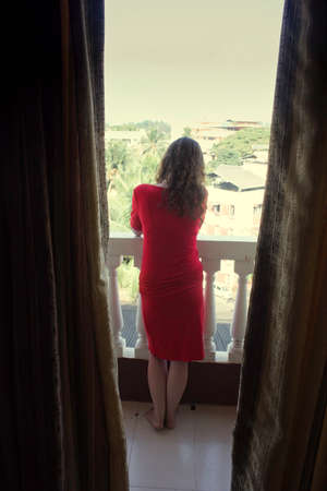 A woman standing in a balcony in Goa, India enjoy the view outsideの写真素材