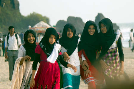 Kerala, India - March 08, 2014: Students happily taking a walk on a beach in Kerala after finishing their studies.のeditorial素材