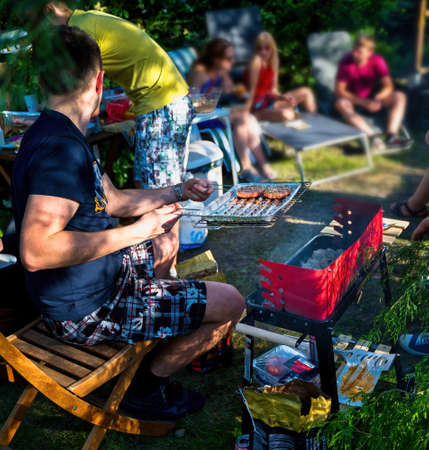 Krakow, Poland: Outdoor Barbecue preparation on a sunny day amongst friends