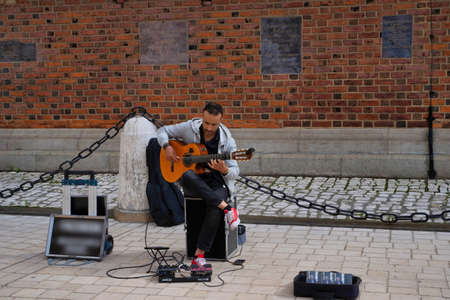 Krakow, Poland - July 12, 2020: A male street performer playing acoustic guitar in the city centerのeditorial素材