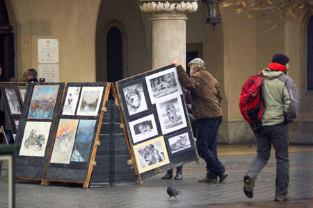 Krakow, Poland - December 16, 2014: A sketch painting artist stand next to his artwork in city center main square during Xmas holidaysのeditorial素材