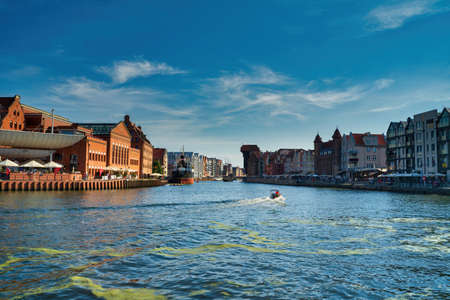 Gdansk, North Poland - August 13, 2020: Panoramic view of summer in motlawa river adjacent to beautiful european architecture near baltic sea during covid 19 pandemic against blue skyのeditorial素材