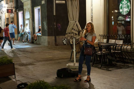 Gdansk, North Poland - August 15, 2020: A female musician playing musical instrument trumphet in the...