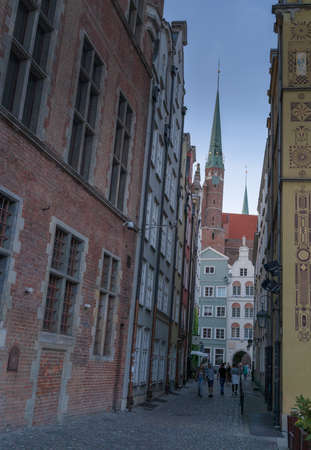 Gdansk, North Poland - August 13, 2020: People taking a walk on a street of main square city center through polish medieval architecture near neptune's fountainのeditorial素材