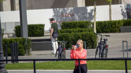 Gdansk, North Poland - August 15, 2020: A female girl taking picture with cellphone over motlawa...