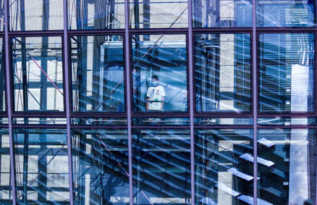 Gdansk, North Poland - August 15, 2020: A little kid wearing mask standing in an elevator inside transparent modern buildingのeditorial素材
