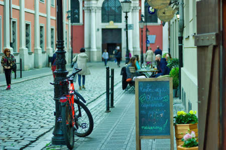 Wroclaw, Poland - May 10, 2019: Tourist dining in the busy street of Polish old town in the main city center. A black board with special menu of the day can be seen outsideのeditorial素材