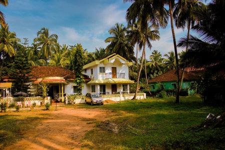 Goa, india - October 24, 2018: A middle class house built on portuguese theme around palm trees in exotic location against blue skyのeditorial素材