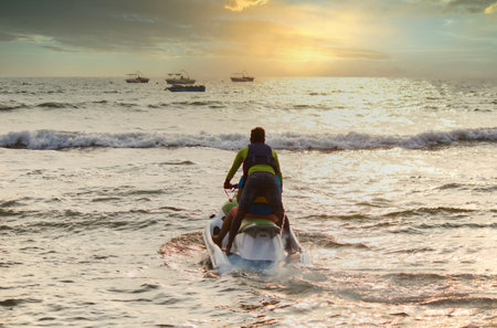 Goa, India - October 25, 2018: A jet ski moving swiftly against waves towards sunset in an arabian...