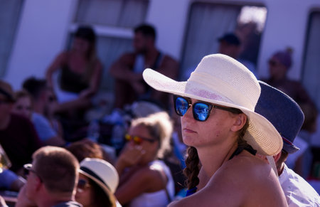 Crete, Greece - September 15, 2017: A girl who is one of the tourist wearing a hat and blue sunglasses sitting on a passenger cruise sailing in Gramvousa Peninsula during summerのeditorial素材