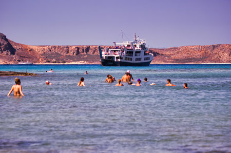 Crete or Kreta, Greece - September 15, 2017: Tourists swimming against ship cruise docked in Balos lagoon Beach, Gramvousa Peninsula in Kreta island during summerのeditorial素材