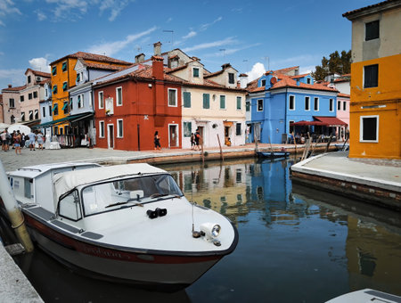 Venice, Italy - September 03, 2018: Wide angle shot of a white jet boat against colorful building architecture located in Burano islandのeditorial素材