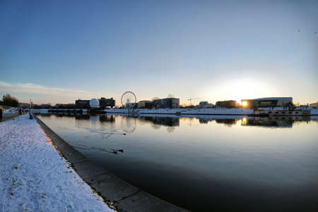 Krakow, South Poland - January 31, 2021: Pan shot of Vistula river against polish building located at the center of the city during peaceful sunset sunrise in winter. Krakow cityscapeのeditorial素材