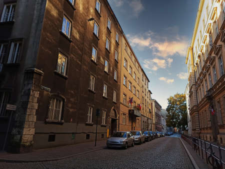 Krakow, Poland - March 17, 2020: Bunch of cars parked in line in a narrow empty street between European style building against dramatic skiesのeditorial素材
