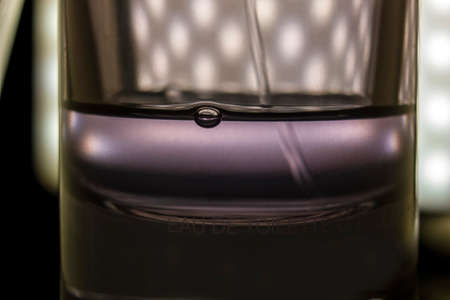 Extreme close up macro shot of a bubble formed inside a bottle of perfume all in a spray of water on...