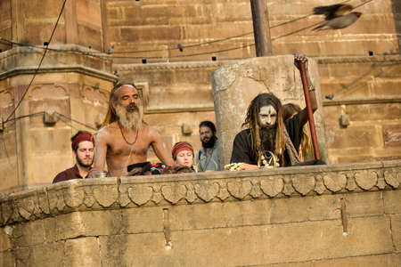 Varanasi, India - November 01, 2016: Bunch of tourists, sadhu baba and pilgrims in sitting posture...