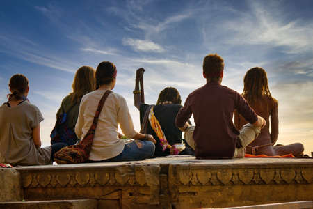 Varanasi, India - November 01, 2016: Bunch of tourists, sadhu baba and pilgrims in sitting posture...