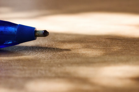 A micrograph macro shot of a tip of a ballpoint pen. On the surface of the ball is visible ink and cracks with a lot of scratches. light and shadow and selective focusの写真素材