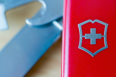Krakow, Poland - April 20, 2021: Selective focus extreme macro shot of Swiss knife logo against out of focus blades. Shallow depth of field.のeditorial素材