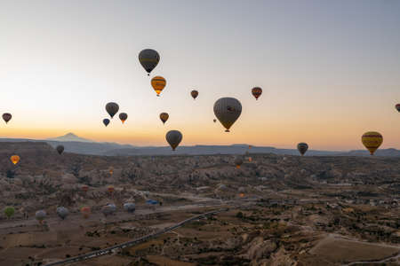 Cappadocia, Turkey - September 14, 2021: Wide angle aerial shot of colorful hot air balloons together floating in the sky at early morning sunrise horizon in Goreme national parkのeditorial素材