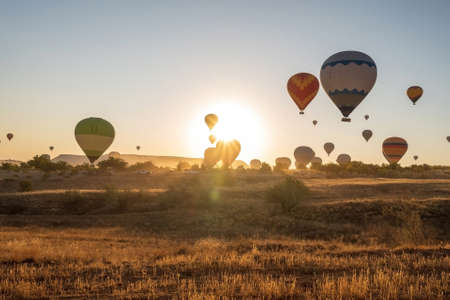Bunch of colorful hot air balloon flying early morning against sunrise in Cappadocia, Turkey against...