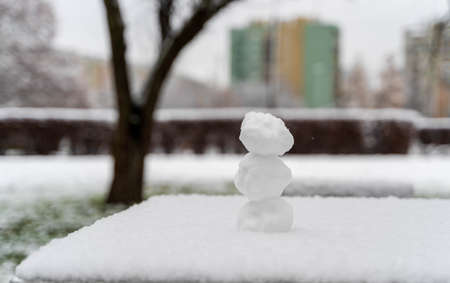 Round real snow balls kept on each other vertically on a table covered with lots of snow against blurred background in winter season.の写真素材