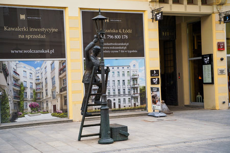 Lodz, Poland - July 08, 2022: Monument to lamp in Lodz. Statue of unnamed electrician standing at...