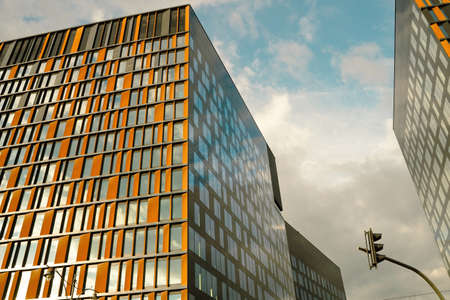 Wide angle view of modern corporate office building architecture with glass and metallic construction with reflection against blue clouds located in Lodz, Polandの写真素材