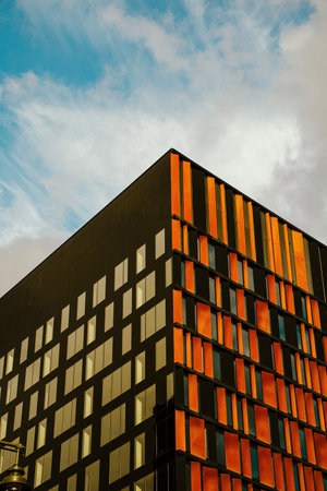 Close up shot of a modern corporate office building architecture with glass and metallic construction with reflection on it.の写真素材