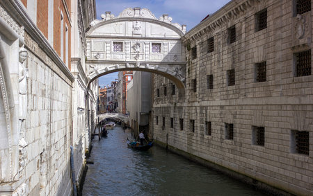Venice, Italy - September 03, 2018: Helmsman on gondolas or boat in a canal against Pont des Soupirs (Bridge of sighs) located in the centreのeditorial素材