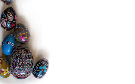 Easter eggs decorated and feathers on white painted wooden background