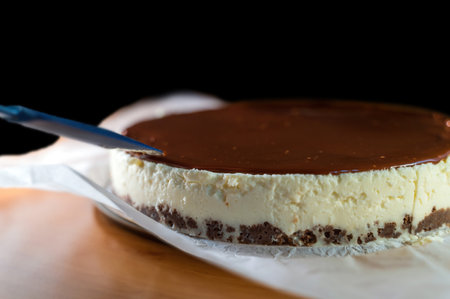 A knife cutting a full cake with coconut, biscuit and chocolate cream on top, birthday conceptの写真素材