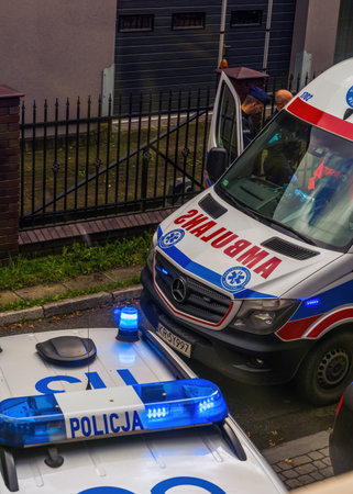 Krakow, Poland - October 02, 2022: A European police in uniform using on duty in front of police car next to an ambulance. Crime scene and investigation conceptの写真素材