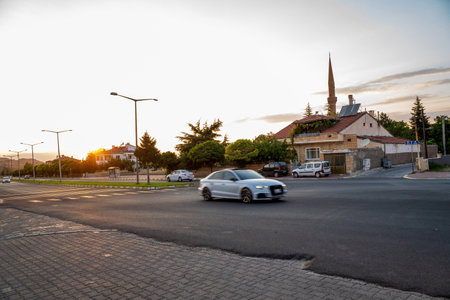 A view of a road with vintage cars and mosque in the background against dramatic sunset / sunriseの写真素材