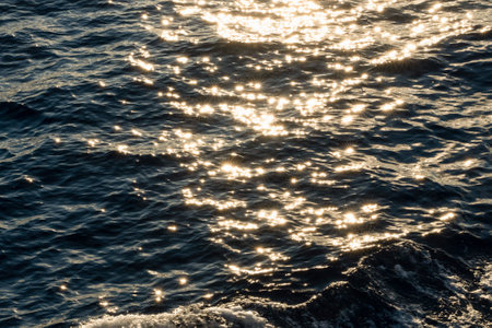 Lens star formed on water body on a sea, A calm ocean reflects sun stars in the morning light.の写真素材