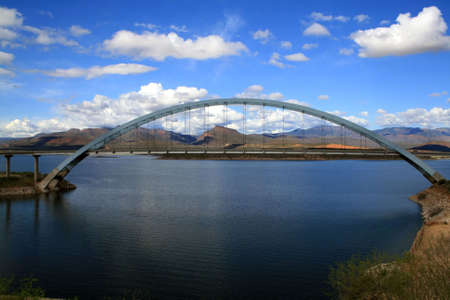 Bridge over lake in front of mountainsの写真素材