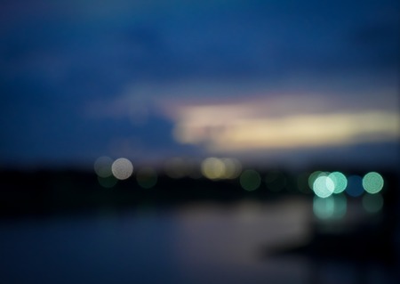 Blurred lights abstract city at night with dark blue black color bokeh sky and cloud.の写真素材