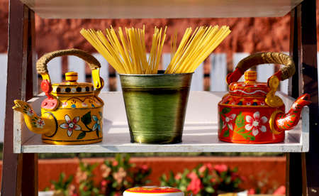 Show piece of Tradition tea pots with raw spaghetti in brass bowlの写真素材