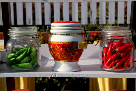 Show piece of Tradition tea pots with green and red chilli in glass containerの写真素材