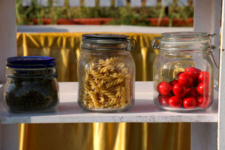 Show piece of pasta cherry and pulses in glass containerの写真素材