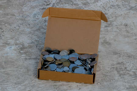 stack of Indian coins in brown paper box
