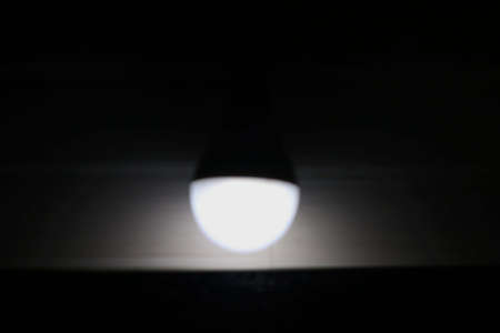 view of blur image of glowing bulb in dark room