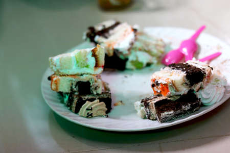 Different flavor pastry cake in plate with plastic spoonの写真素材