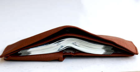 Brown leather wallet with money on floorの写真素材