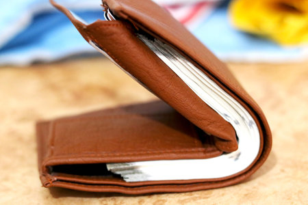 Brown leather wallet with money on floorの写真素材