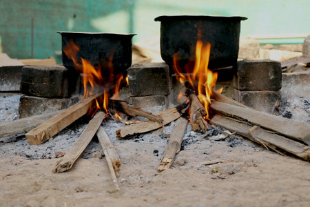 Traditional way of making food on open fire in old Indian kitchen in a village Chula.の写真素材