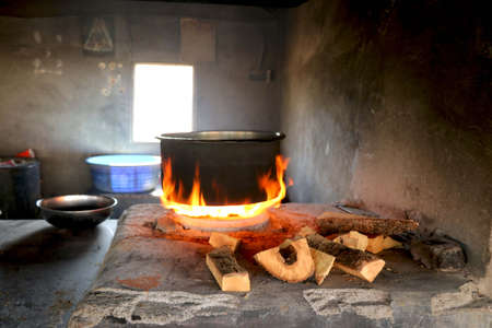 Traditional way of making food on open fire in old Indian kitchen in a village Chula.の写真素材